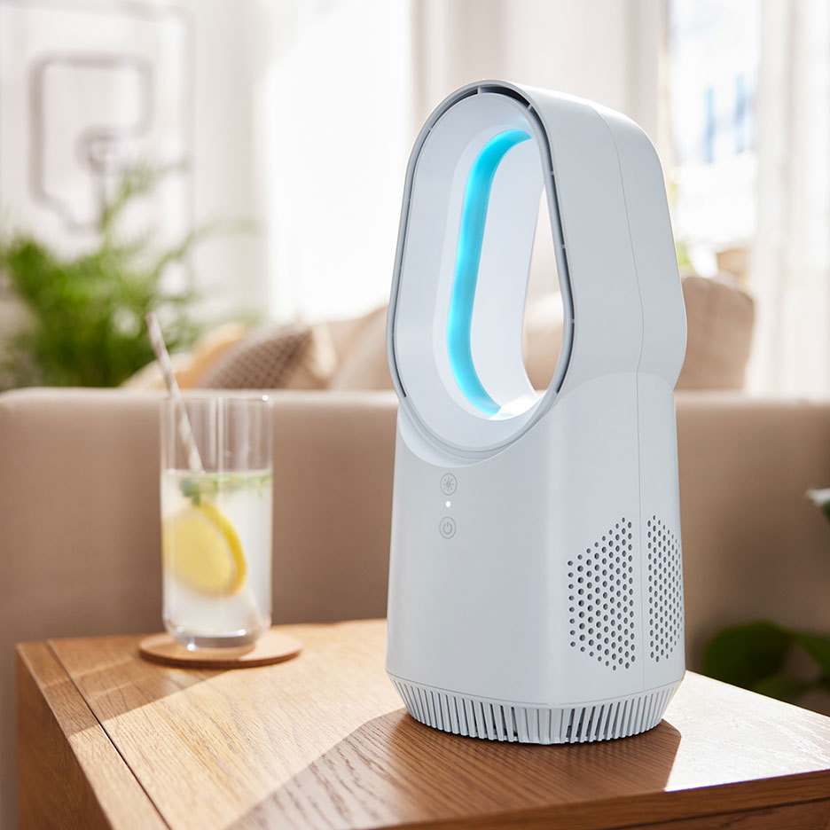 Bel ventilator brez lopatic z modro svetlobo na leseni mizi s pijačo.