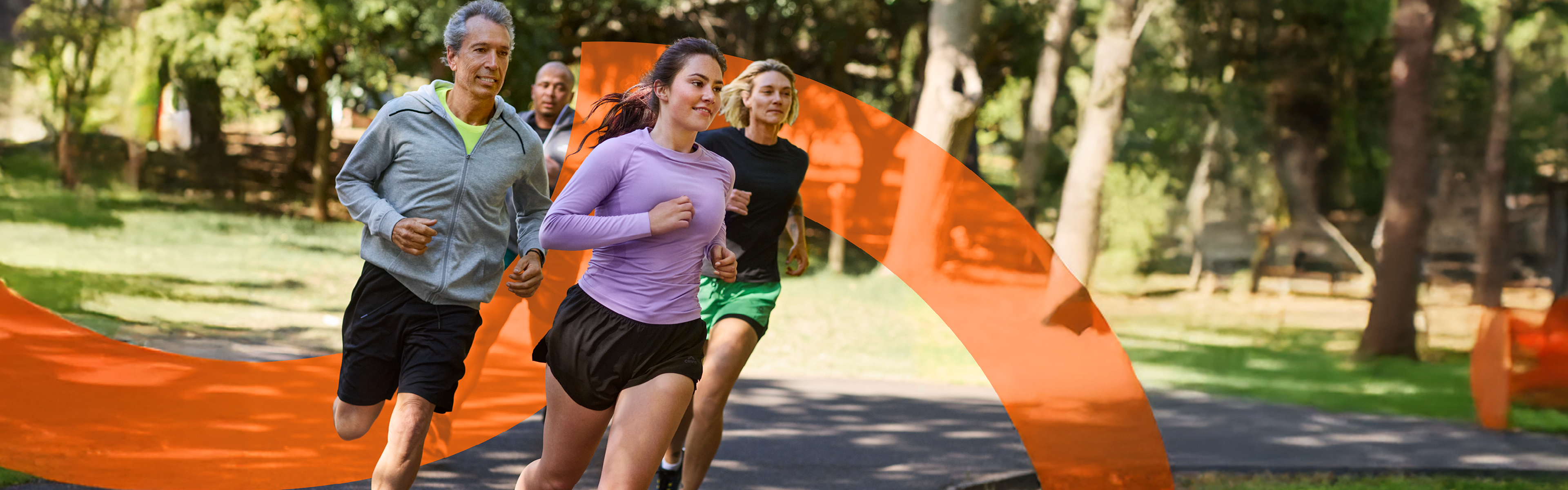 Štirje ljudje tečejo v parku, oblečeni v športna oblačila Crivit.