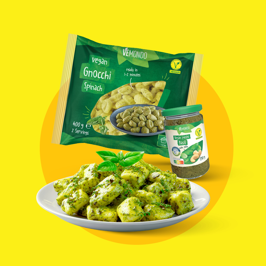 Veganski špinačni njoki in veganski pesto z baziliko, postreženi na krožniku.