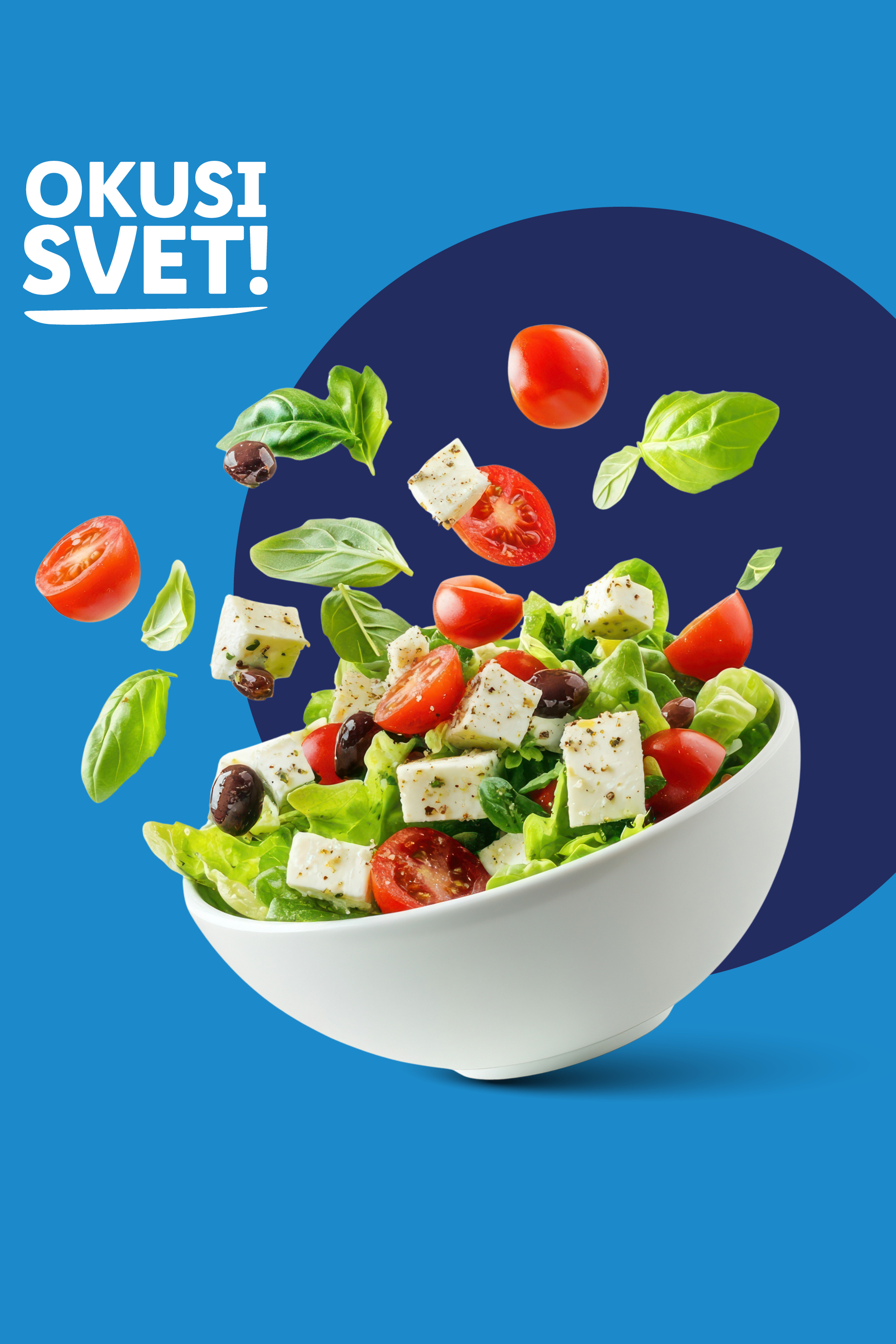 Skleda grške solate z lebdečimi sestavinami in napisom 'OKUSI SVET!'.