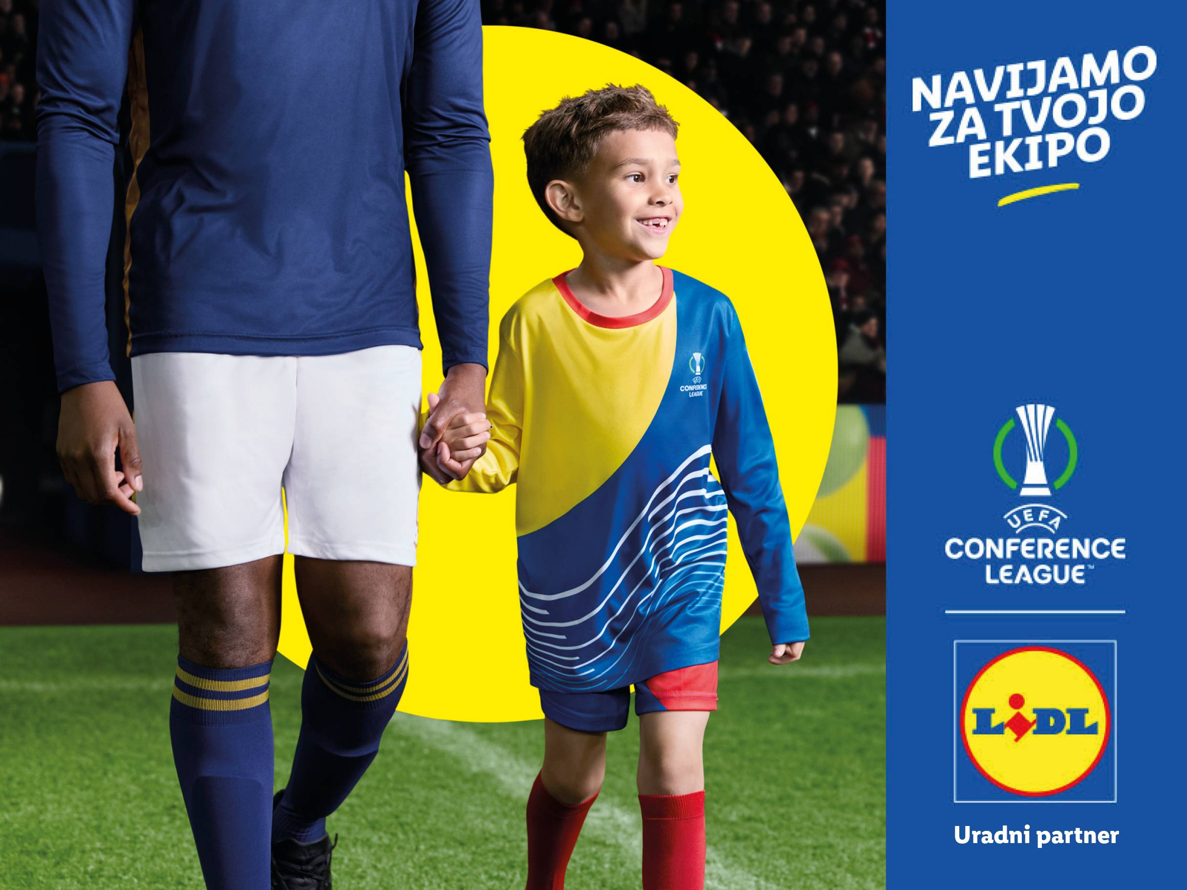 Odrasel in otrok v nogometnih dresih, z logotipoma UEFA Conference League in Lidl.