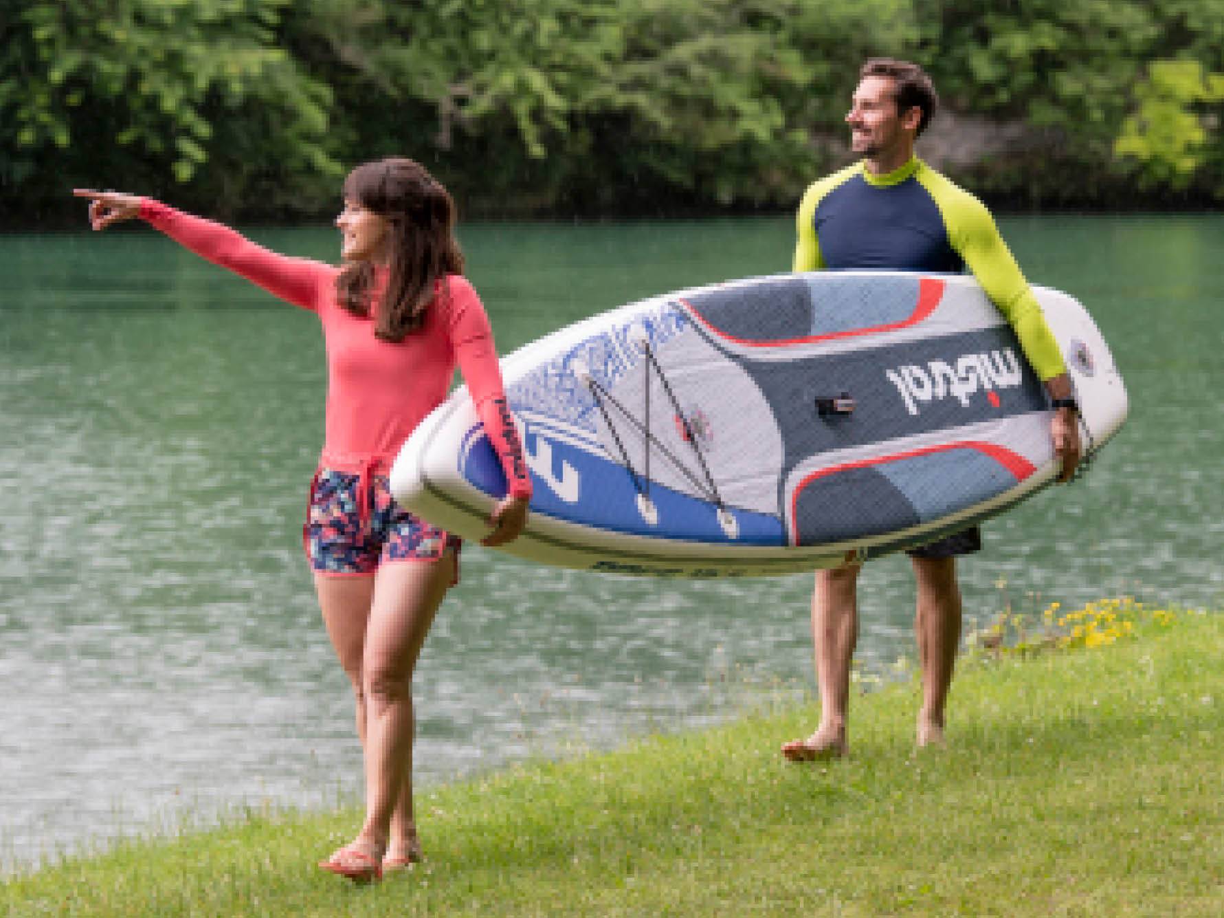 Par Red Paddle Co SUP desk, ki ga nosi par ob vodi.